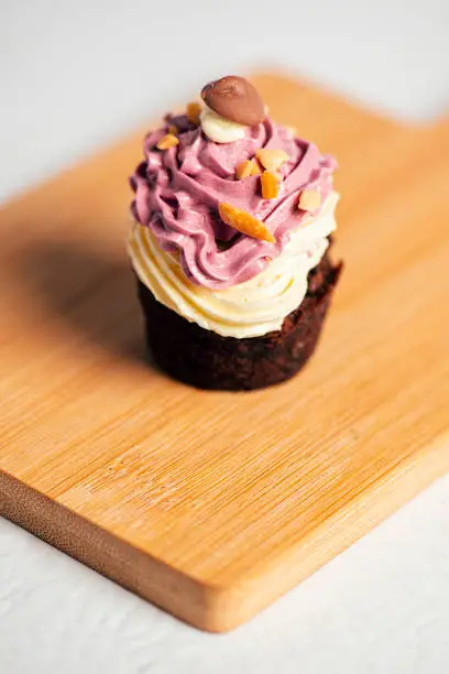 Chocolate cupcake with Swiss meringue buttercream, dessert food background.