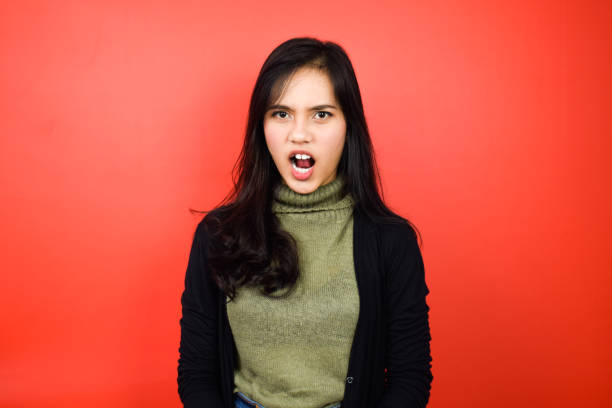 istock Young beautiful asian women using black sweater with red isolated background 1293098519
