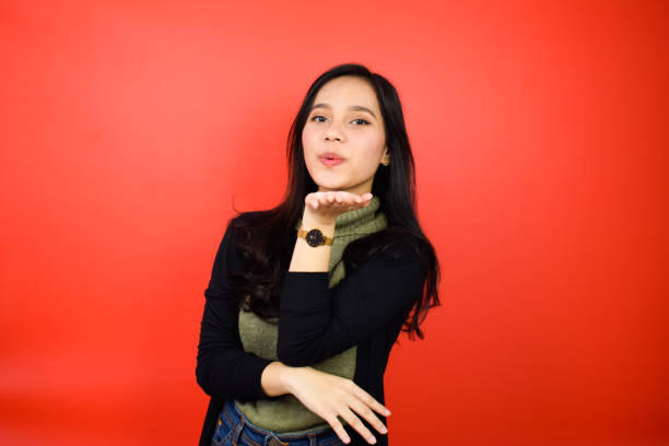 istock Young beautiful asian women using black sweater with red isolated background 1293099246