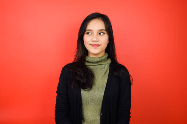 istock Young beautiful asian women using black sweater with red isolated background 1293099279