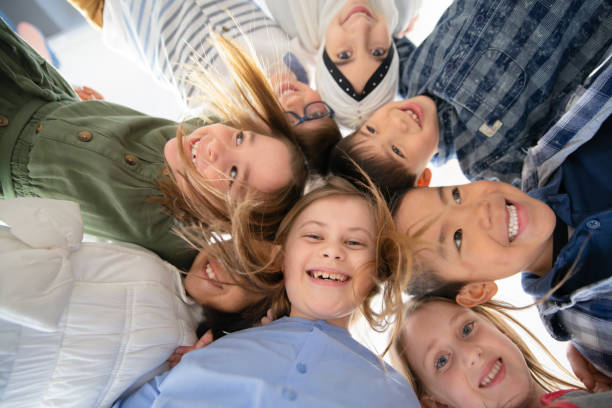 istock An Adorable Group of Diverse Kids Look Down at Camera While Huddled Together 1293099550