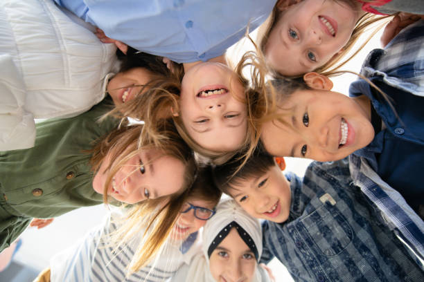istock An Adorable Group of Diverse Kids Look Down at Camera While Huddled Together 1293099561