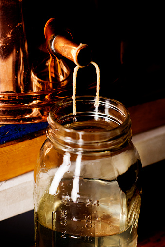The final output of an alcohol still…the distilate dripping from the condenser into a collection jar.