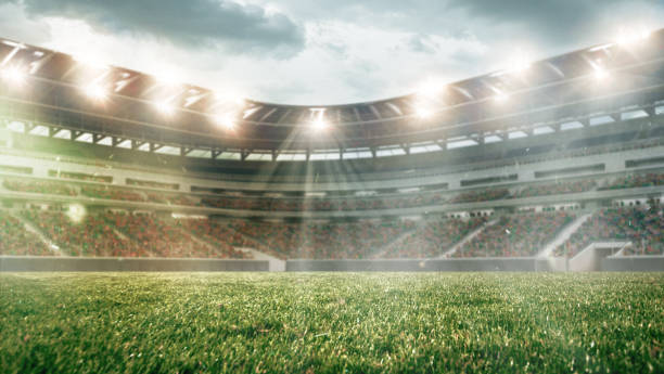 campo da calcio con illuminazione, erba verde e cielo nuvoloso, sfondo per design o pubblicità - football foto e immagini stock