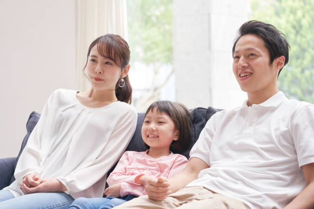istock Asian family smiling on the sofa 1293109743