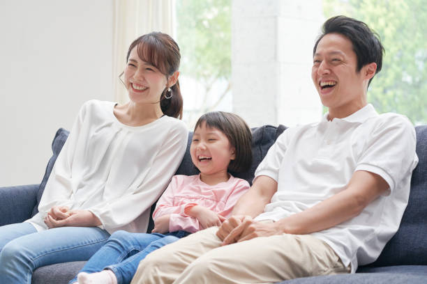亞洲家庭在沙發上微笑 - 僅日本人 圖片 個照片及圖片檔
