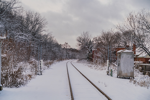 Cambridge, UK. Train tracks at Cambridge train station in poor winter weather conditions. The train tracks are icy and covered in snow.