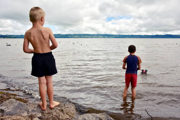 istock Boy by Lake with Remote Control Boat 1293120386