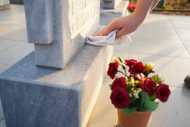 cemitério de limpeza. a mão de uma mulher lava monumento cinza no túmulo com pano - lápide - fotografias e filmes do acervo