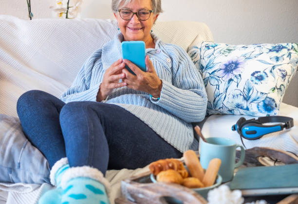 istock Senior woman relax in sofa at home using smartphone 1293135718