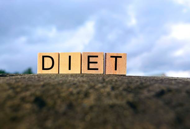 istock Diet text on wooden cube block on top of big stone with blurred tree and sky background 1293136855