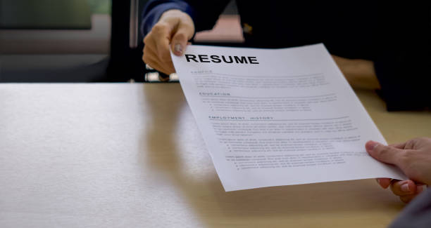 istock Candidate handing resume to human resource manager before start the interview. Close up 1293141698
