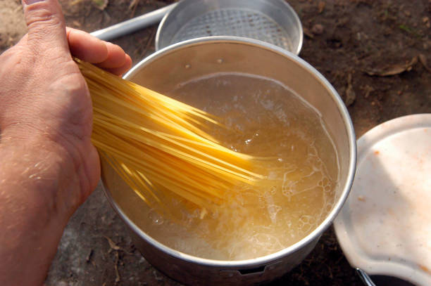 cooking spaghetti in boiling water putting spaghetti in a pot with boiling water for cooking guzzling stock pictures, royalty-free photos & images