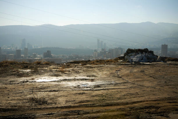 vista de uma cidade com lama espessa em primeiro plano. - smog city pollution town - fotografias e filmes do acervo