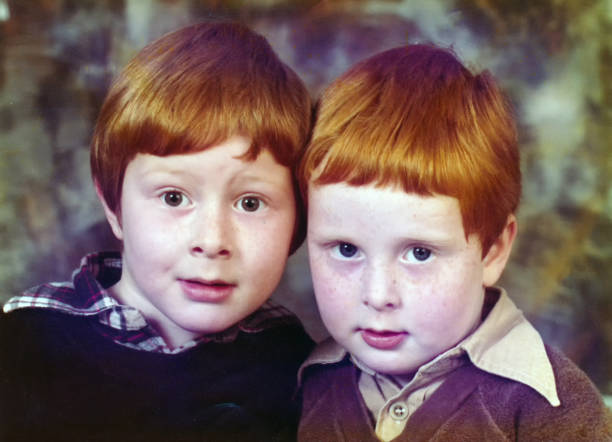 Two little brothers with auburn hair and freckles. Early 1980s portrait of two little brothers, side by side,  with ginger hair and freckles. emo boy stock pictures, royalty-free photos & images
