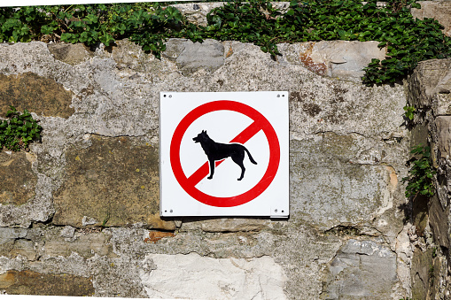 No dogs or pets allowed, warning sign at wall .