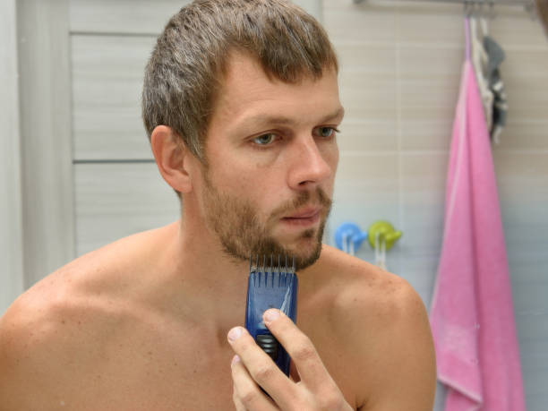 istock A man in a bathroom cuts a heavily regrown beard 1293149327