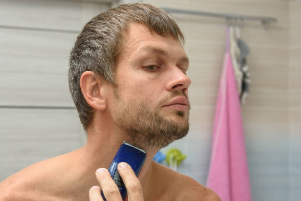 istock A man smooths his beard on his face with a hair clipper 1293149330