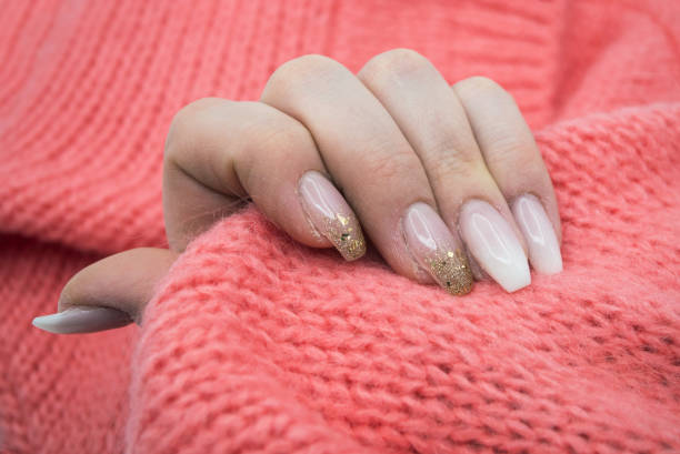 istock hand of woman with beautiful nails in pink pullover background 1293151987