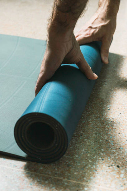 istock Middle-aged man picks up a yoga mat at home 1293153755