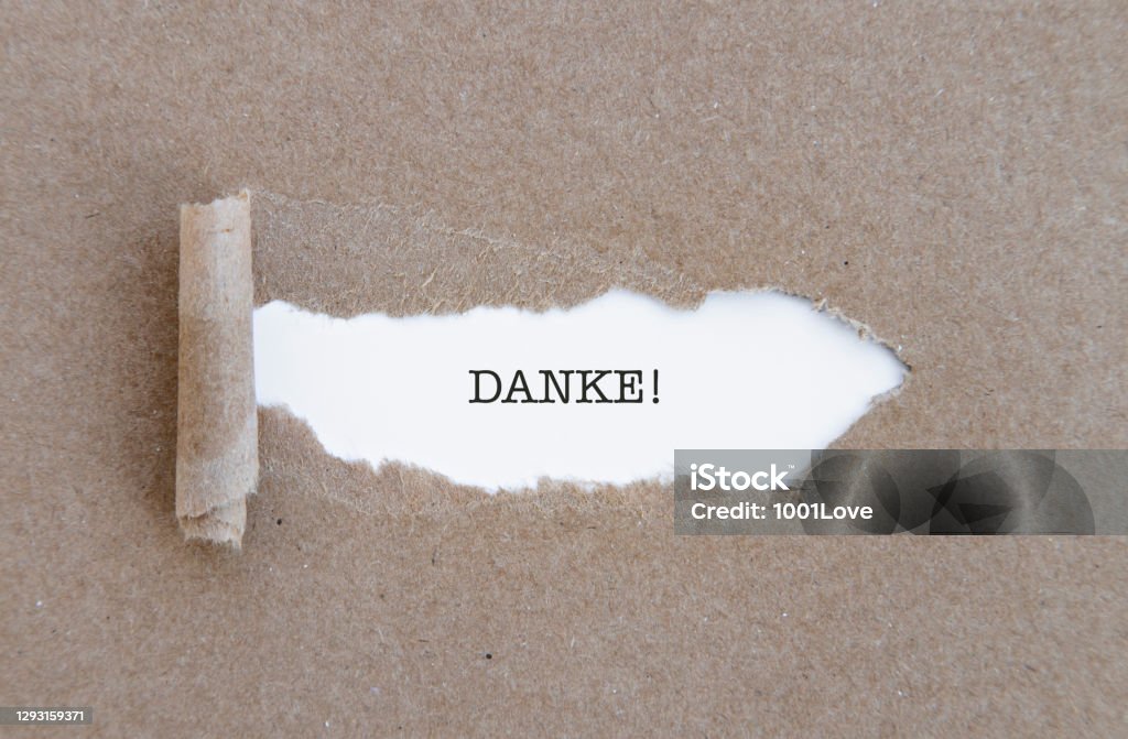 Thank you in German, Danke word written under torn paper. 2020 Stock Photo