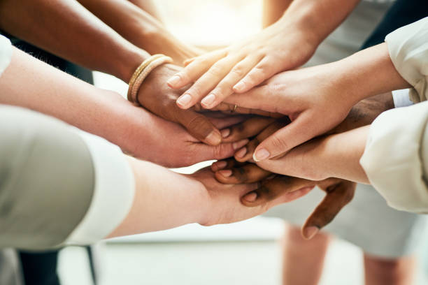 We're all in this together Cropped shot of a group of unrecognizable businesspeople standing in the office with their hands in a huddle hands clasped stock pictures, royalty-free photos & images