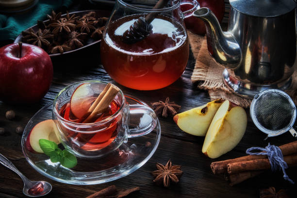 visão de close-up de alto ângulo de uma xícara de maçã e infusão de chá quente de canela em uma mesa em uma cozinha rústica - stevia tea herbal tea herb - fotografias e filmes do acervo