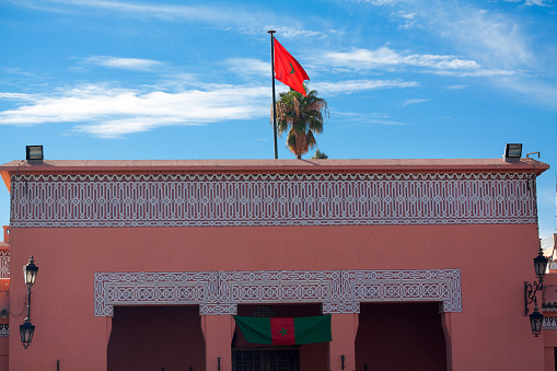 Building with moroccan flag in Marrakech. Building is close to old mosque of Medina