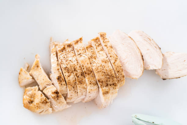 istock Slicing freshly baked chicken breast on a white cutting board. 1293161708