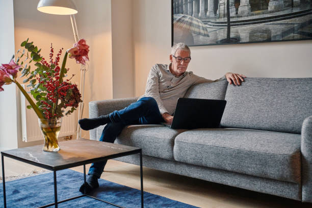 istock Man sitting on sofa with laptop 1293161713