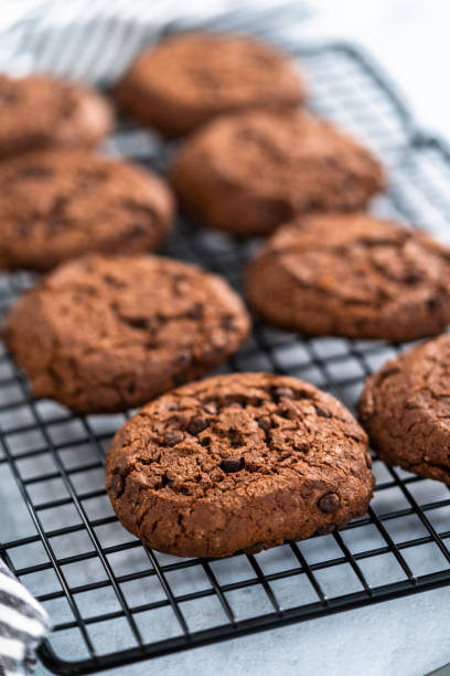 istock Freshly baked double chocolate chip cookies on a cooling rack. 1293161800