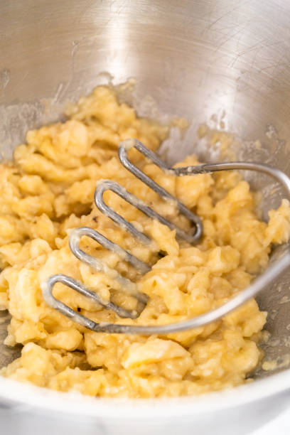 istock Peeling and smashing overripe bananas to make banana nut bread. 1293162471