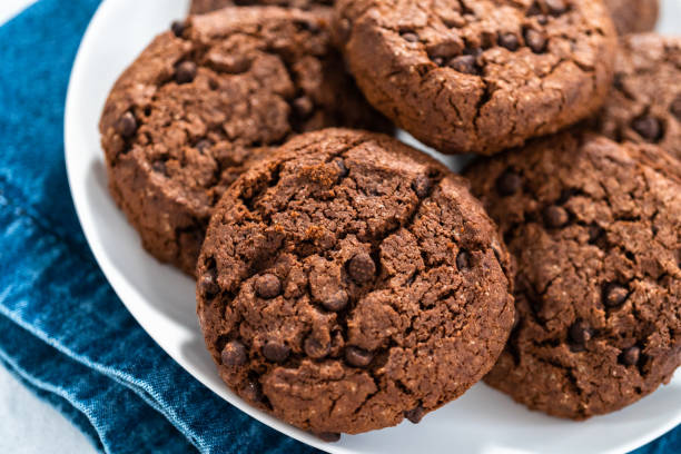 istock Freshly baked double chocolate chip cookies on a white plate. 1293163438