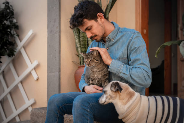 istock young man sitting in the garden interacts with his pets 1293171083