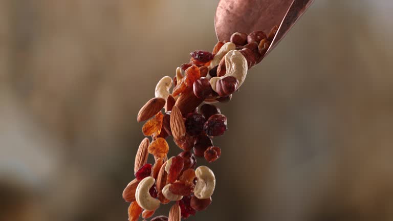 healthy mixture of nuts and berries pouring from a scoop