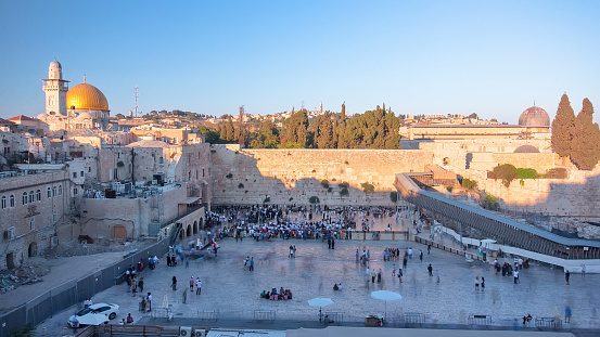 The Temple Mount in Jerusalem, including the Western Wall and the golden Dome of the Rock at Sunset timelapse. Shadow cover the wall. Many peaople at shabbat
