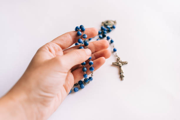 istock Rosary beads held in one hand on white background 1293177834