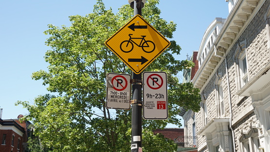 Montreal, QC- Canada - 6-24-2020: Parking challenge. Cycle sign and No Parking signs: left: Wednesdays from 7:00 - 8:00 AM, from Apr 1st to Dec 1st, right: 9:00 AM to 11:00 PM except for sector 13.