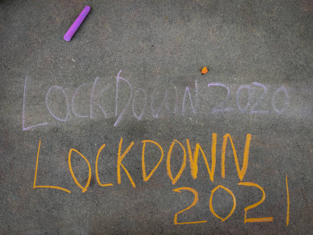 istock The inscription text on the grey board, erased lockdown 2020 and lockdown 2021. Using color chalk pieces. 1293179913