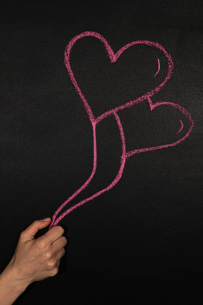 istock Hand holds two heart shaped balloons 1293183340