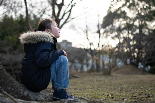 istock Girl sitting on a tree trunk 1293183341