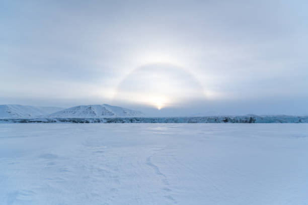 The halo effect above the Königsbergbreen glacier head in Svalbard - ring of light visible around the svalbard sun. stock photo
