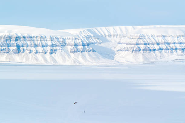 Snowmobiles driving through the valley in Svalbard stock photo