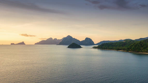 Philippines Palawan Bacuit Bay Islands Sunset Panorama El Nido Moody sunset Panorama of the beautiful Islands and Islets in El Nido Bacuit Bay under moody dusk twilight skyscape. View to Corong Beach and Depeldet Island, Cadlao Island, Helicopter Island, Inambuyod Island and Miniloc Island on the Bacuit Bay Seascape horizon. Drone Point of view Sunset - Dusk Panorama. Bacuit Bay Islands, El Nido, Palawan Island, Philippines, Southeast Asia, Asia. el nido photos stock pictures, royalty-free photos & images