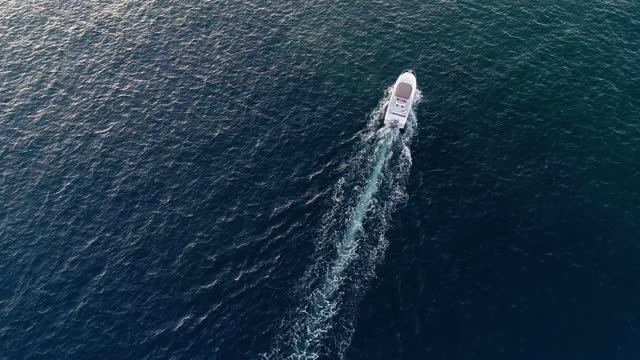 Motor boat in the Mediterranean Sea from above in aerial view. We can see only the boat in the blue sea 4K