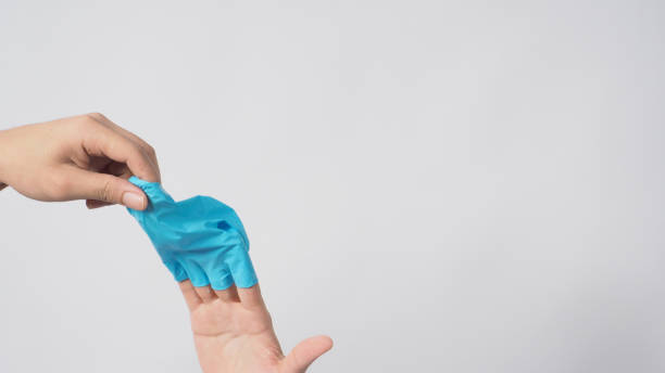 Left hand is pulling right hand with blue latex gloves on white background.