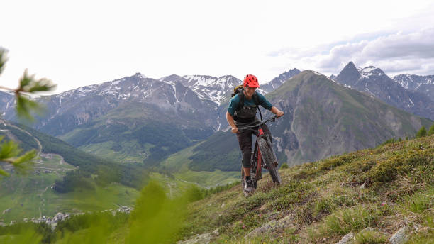 istock Mountain biker ascends grassy meadow in the morning 1293190628