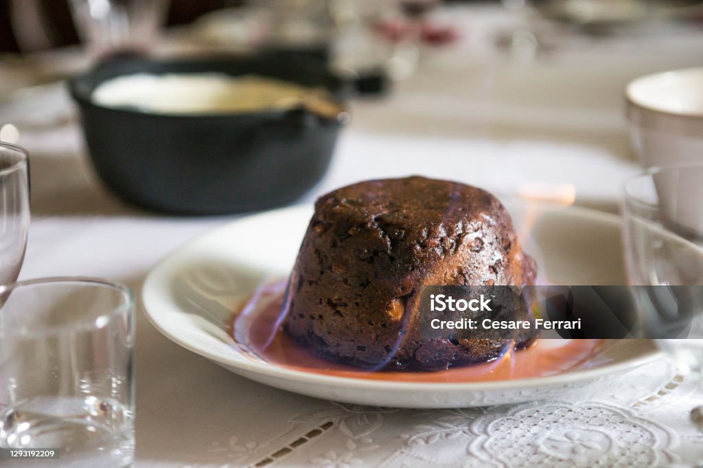 Christmas pudding Close up on a Christmas pudding on fire on a table top. Christmas Pudding Stock Photo