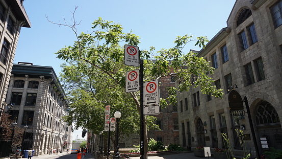 Montreal, QC- Canada - 6-25-2020: Parking challenge. No Parking signs: top: Mon. to Fri 8:00 to 9:00 AM, Apr 1st to Dec 1st, middle: Mon. to Fri 8:00 AM to 6:00 PM, bottom.:except motors