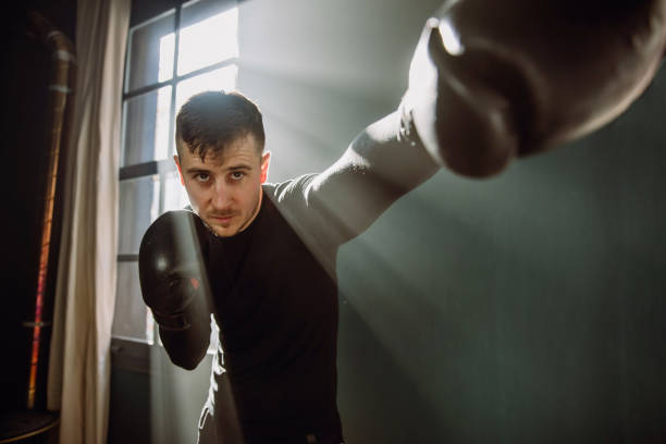 istock The man is an athlete boxing in the gym. Boxer practicing punches in the ring. Shadow-boxing. The athlete strikes with a punching bag. 4k video 1293199559